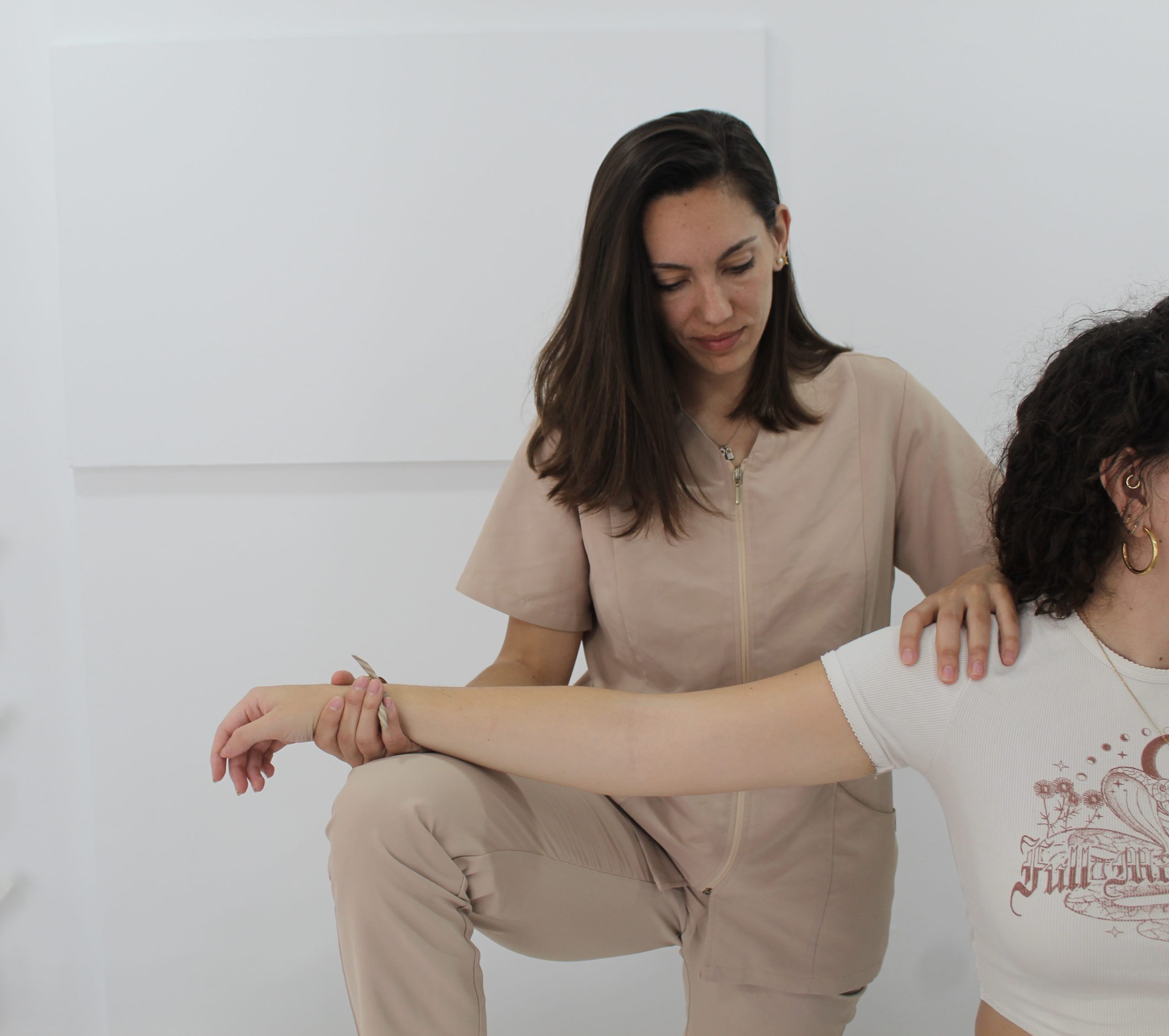 Fisioterapeuta realizando una movilización de brazo en consulta